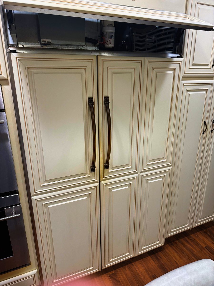 Built-in refrigerator with its upper service panel open during a repair visit — Appliance Rescue Team serves Bergenfield, NJ