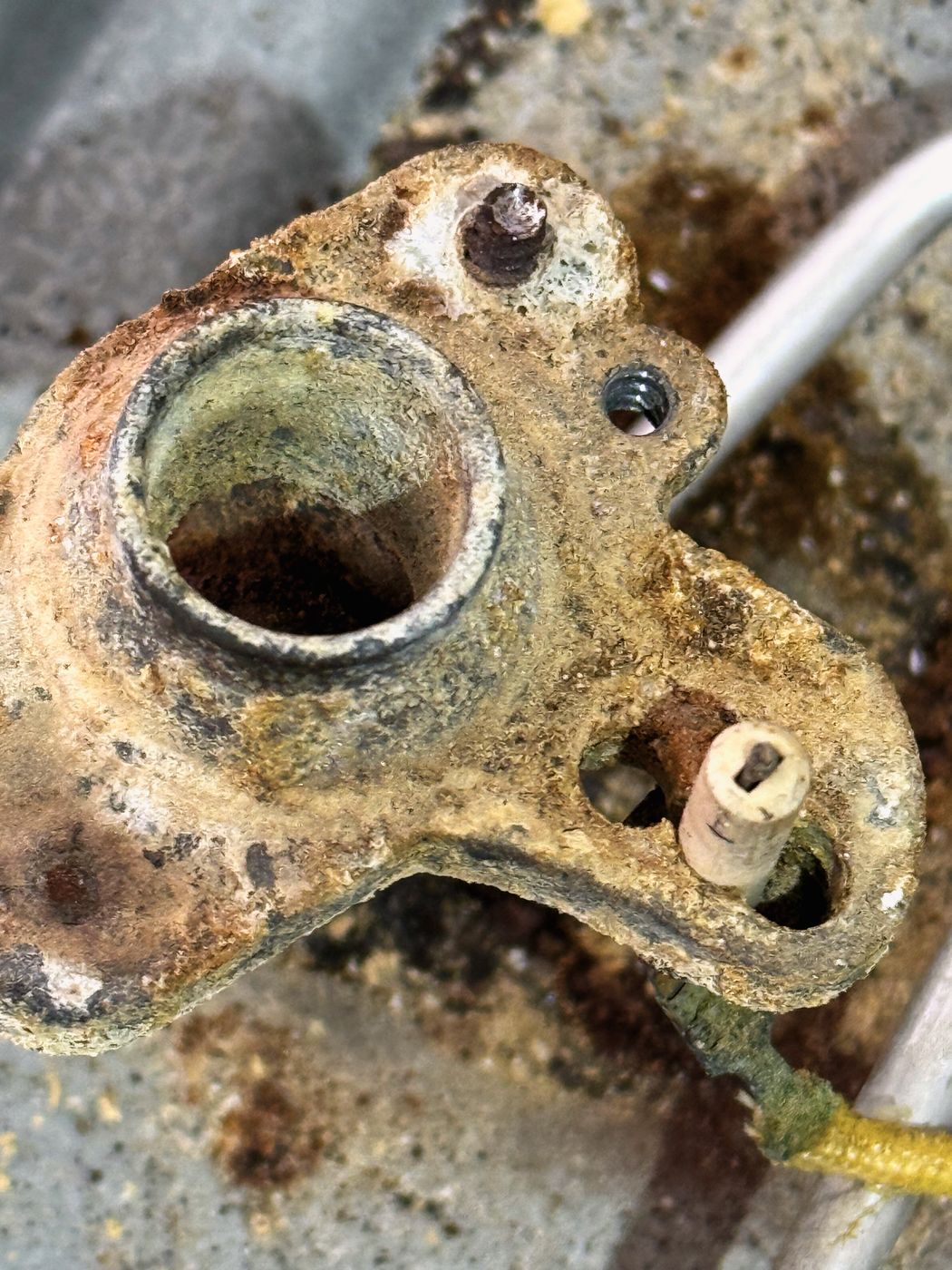 Closer on the corrosion. This is years of moisture and spills sitting under the burner cap, not a sudden failure