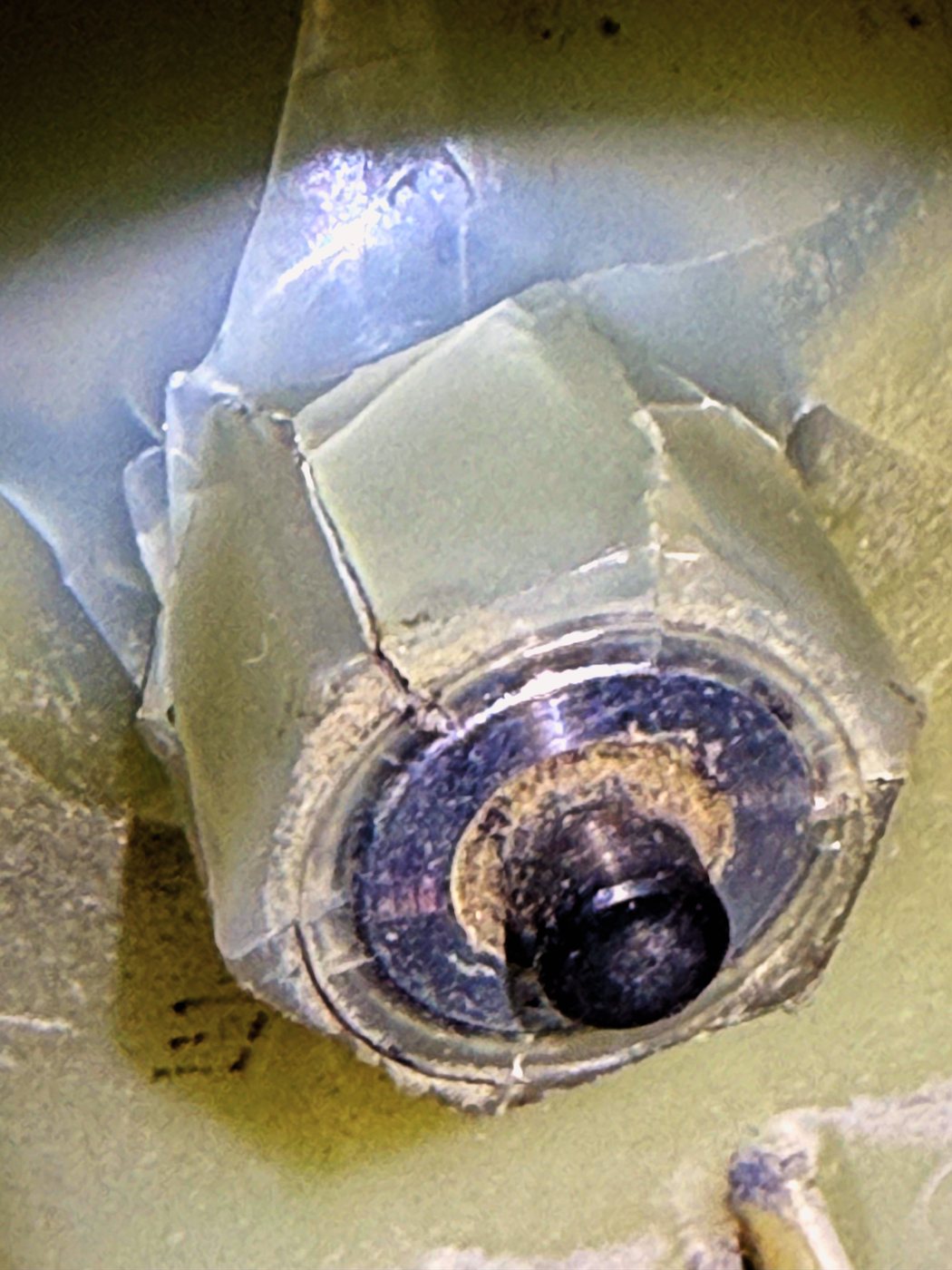 The blower wheel’s plastic hub, split into pieces around the motor shaft. With the hub cracked the wheel no longer sits tight, and a loose wheel is what the noise was