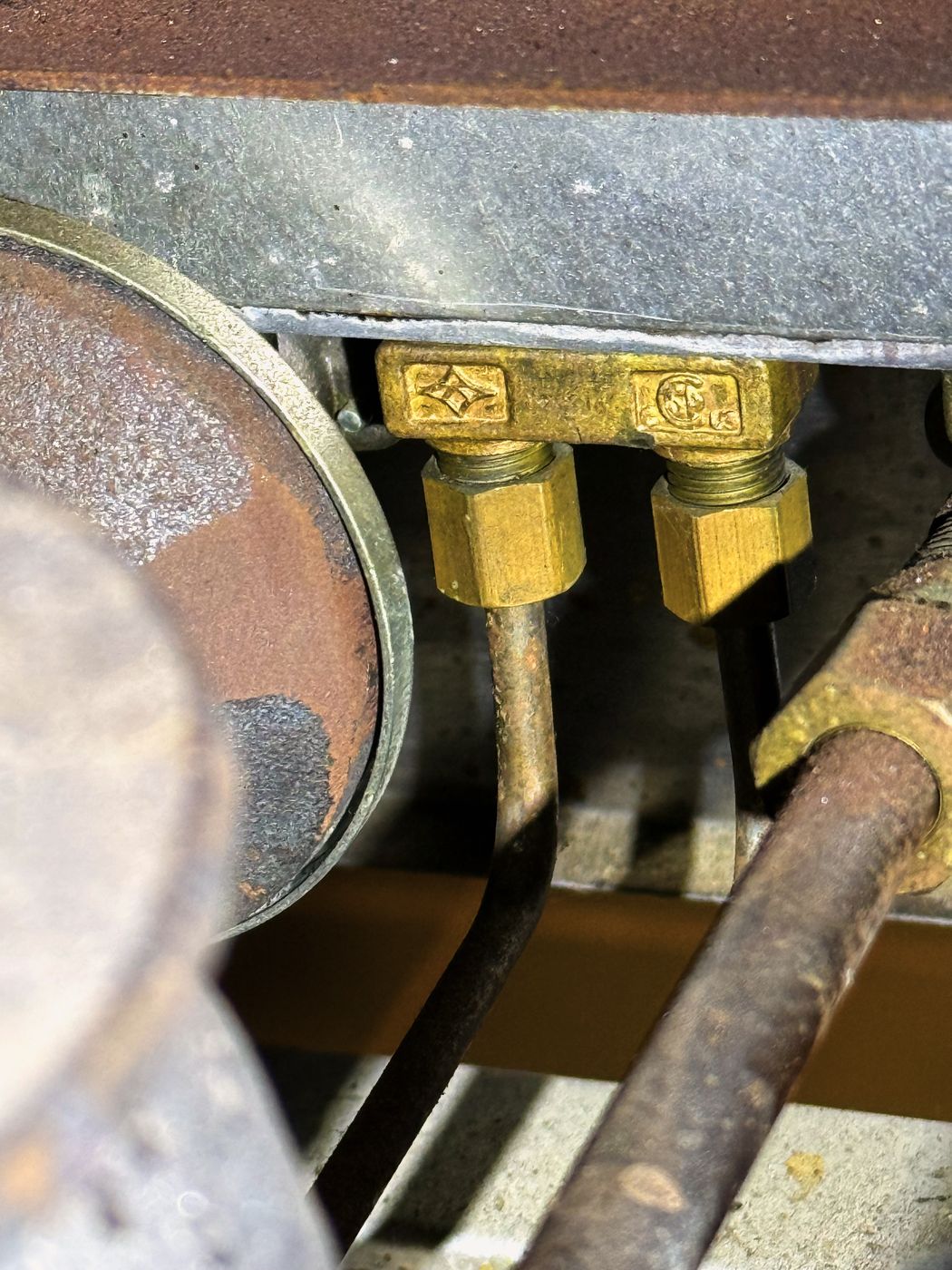 The brass tee under the cooktop and the two thin pilot tubes running from it. This fitting and the tube had corroded through