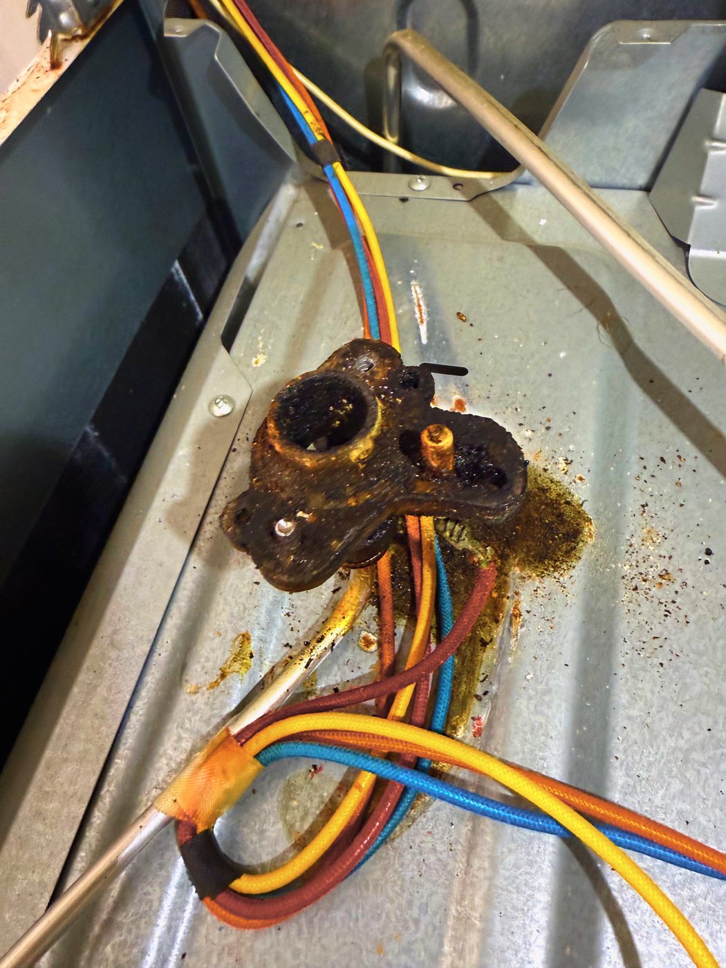 A burner still in place on the cooktop pan, with the igniter wiring running under it